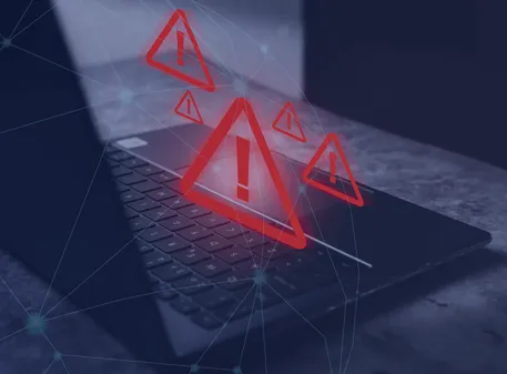 Computadora portátil con señales de advertencia digitales en rojo que representan riesgos y errores comunes al comprar vivienda en Colombia desde el exterior.