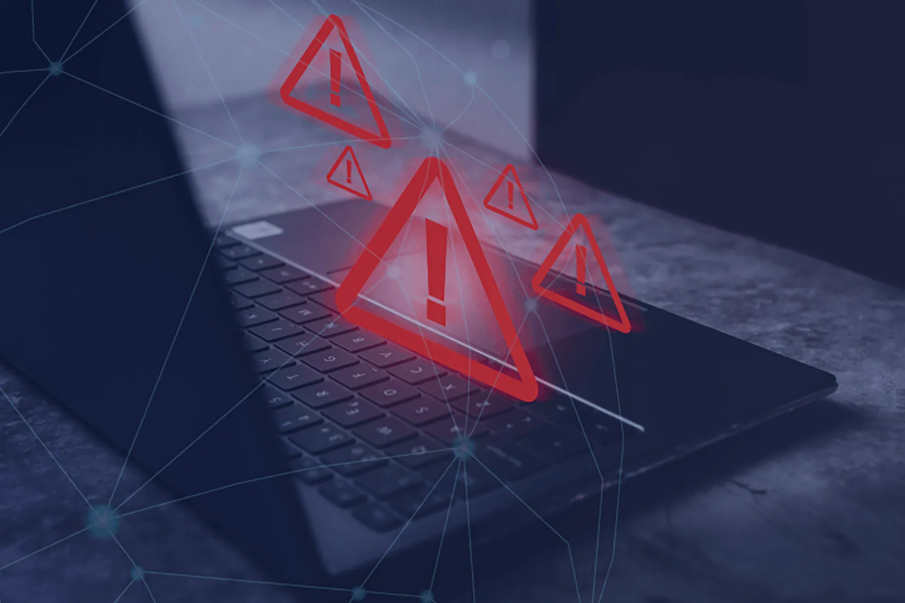 Computadora portátil con señales de advertencia digitales en rojo que representan riesgos y errores comunes al comprar vivienda en Colombia desde el exterior.